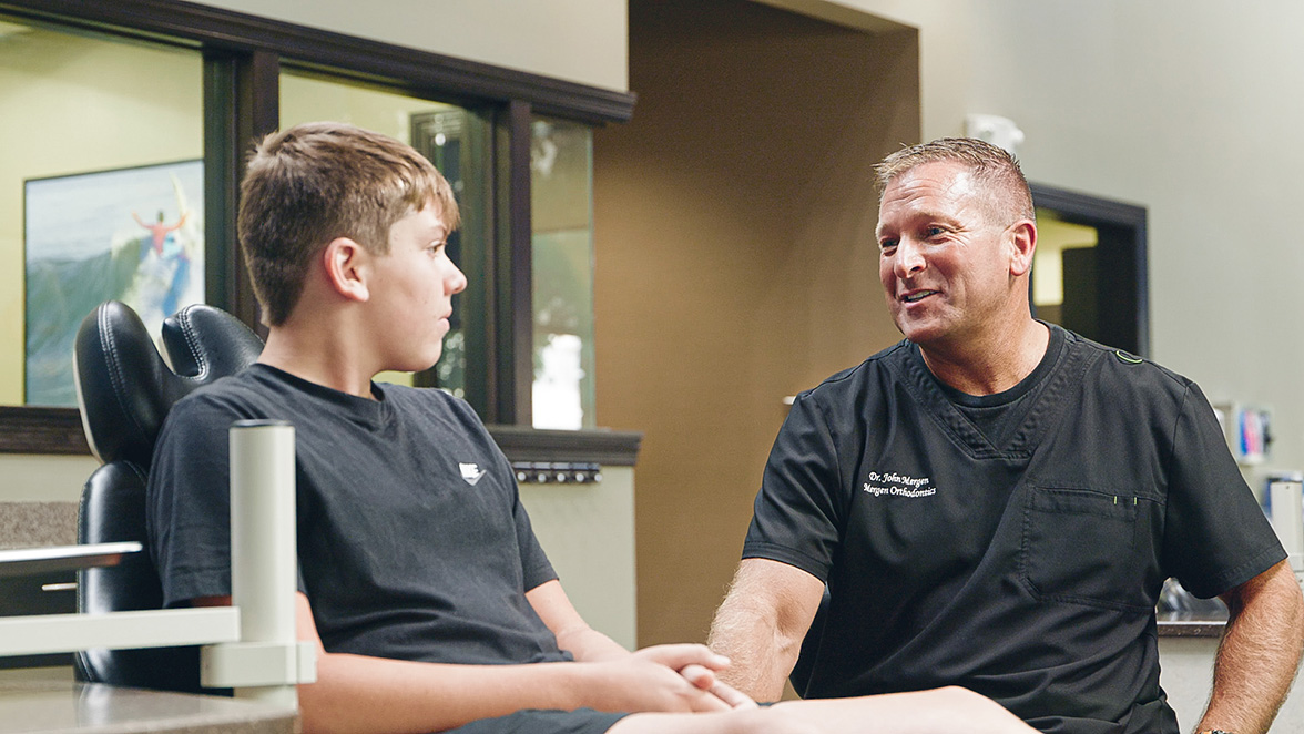 Dr. Mergen talking with a teen patient in the treatment chair