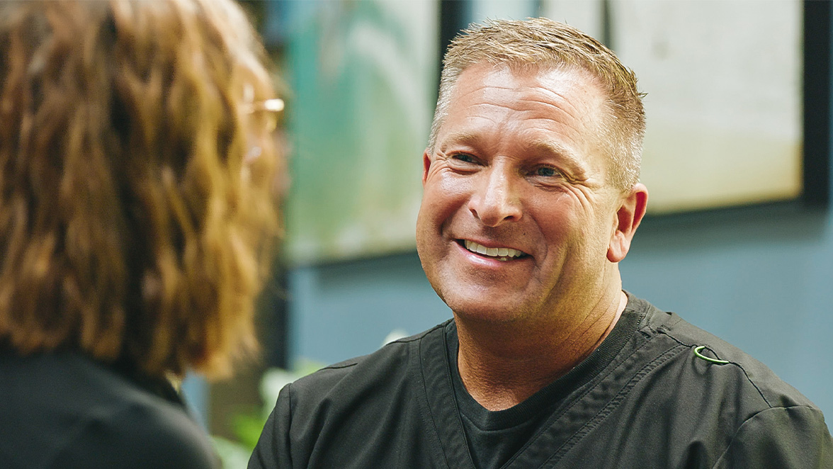 Dr. Mergen smiling with a patient during a consultation